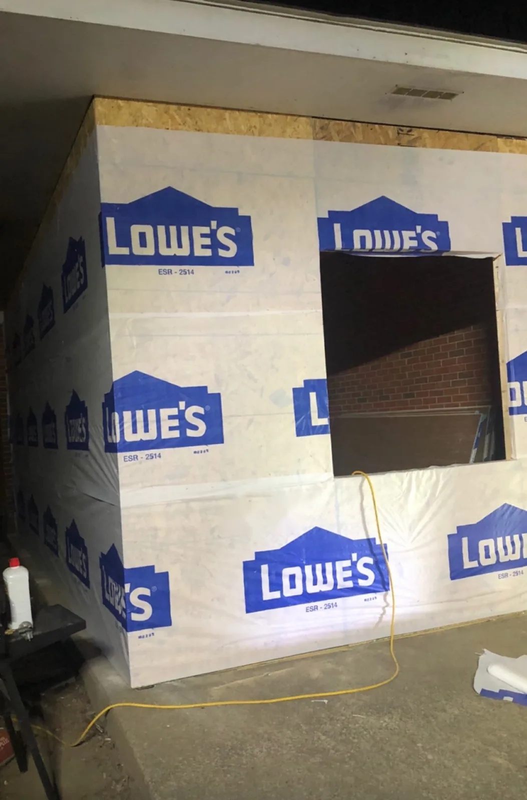 New wall framing covered in house wrap, photographed at night